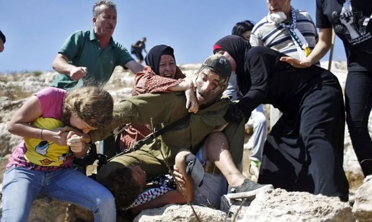 مادر فلسطینی با کتک زدن سرباز اسرائیلی بچه اش را گرفت/گزارش تصویری